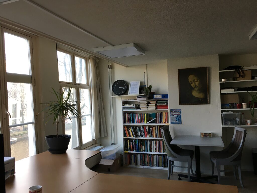 Een impressie van het kantoor van Percival met tafels en een volle boekenkast die de bibliotheek vormt.